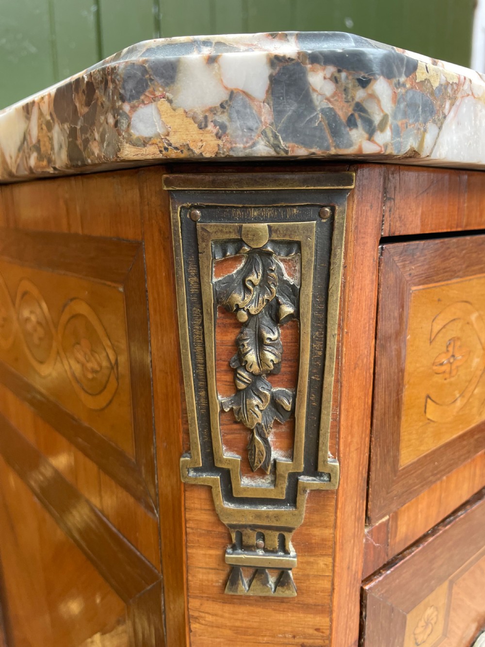 A late nineteenth-century French Louis XVI transitional style commode featuring marquetry wood veneers, brass ring handles, and a grey marble top. View VII