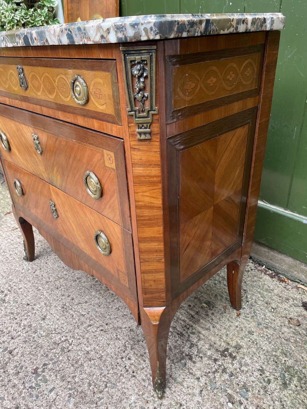 A late nineteenth-century French Louis XVI transitional style commode featuring marquetry wood veneers, brass ring handles, and a grey marble top. View VIII