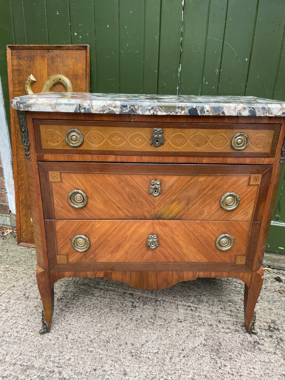 A late nineteenth-century French Louis XVI transitional style commode featuring marquetry wood veneers, brass ring handles, and a grey marble top. View XXI