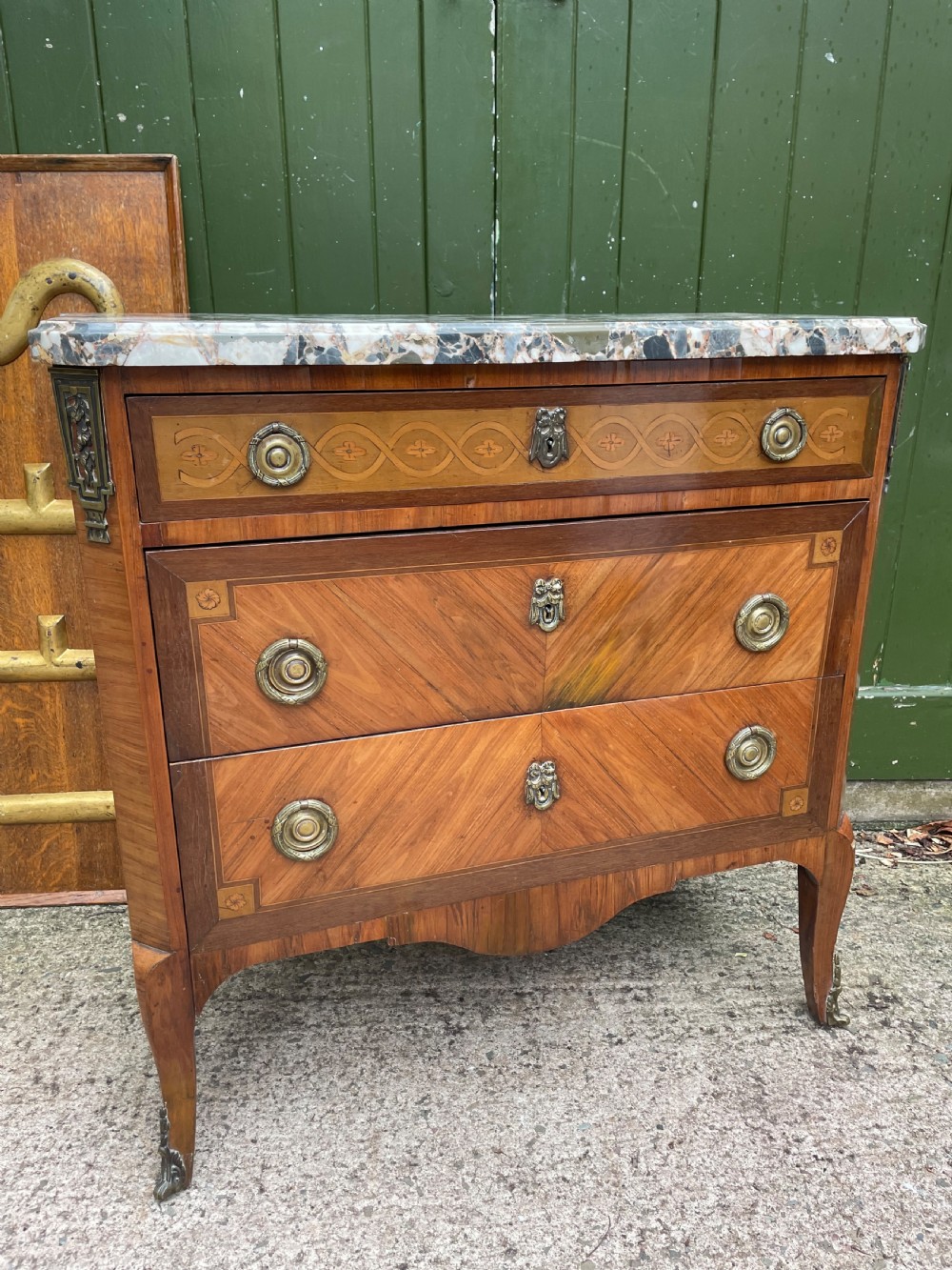 A late nineteenth-century French Louis XVI transitional style commode featuring marquetry wood veneers, brass ring handles, and a grey marble top. View XXII