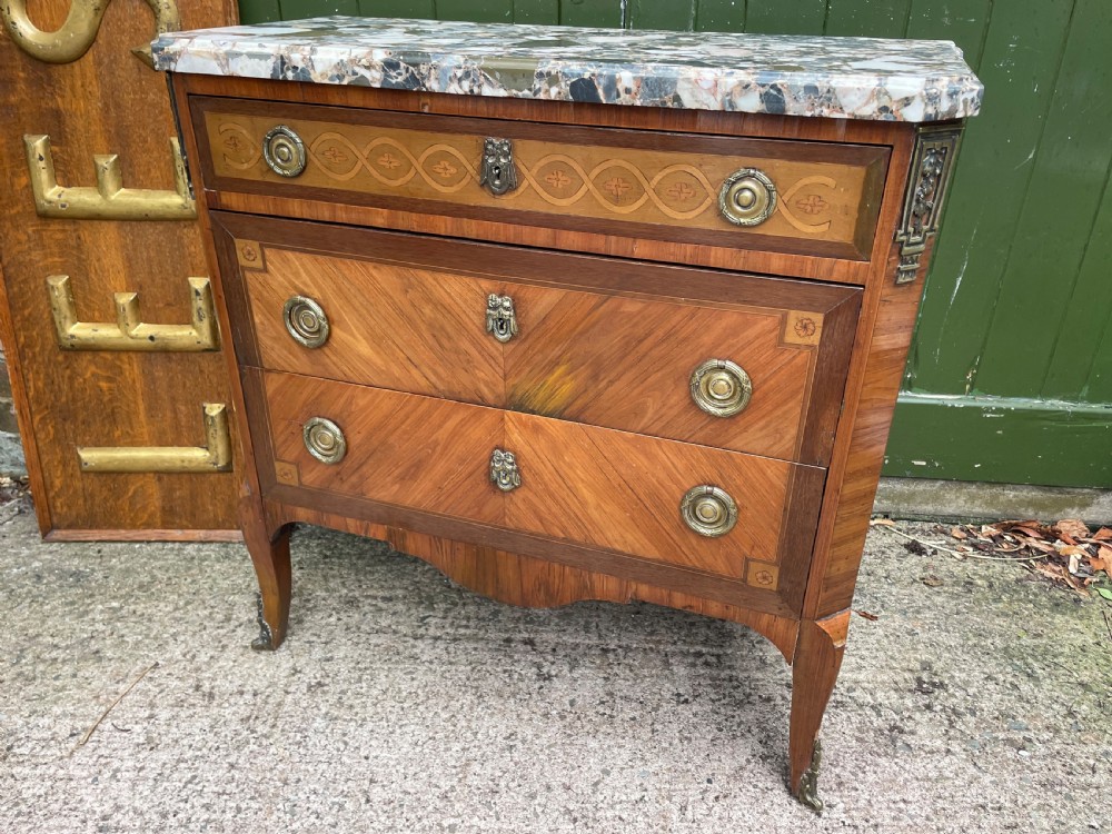 A late nineteenth-century French Louis XVI transitional style commode featuring marquetry wood veneers, brass ring handles, and a grey marble top. View XXIV