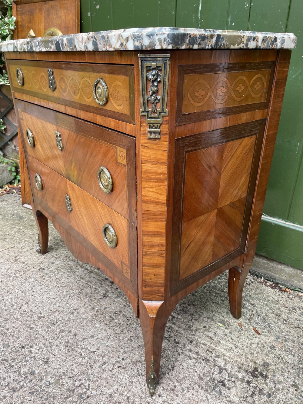 A late nineteenth-century French Louis XVI transitional style commode featuring marquetry wood veneers, brass ring handles, and a grey marble top. View XXV