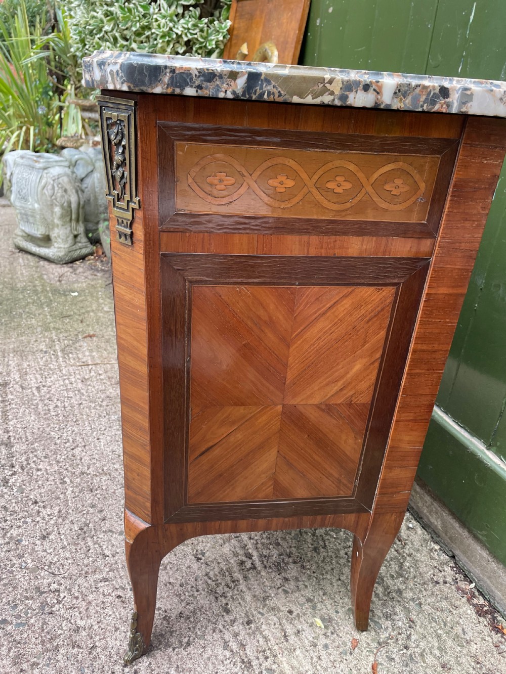 A late nineteenth-century French Louis XVI transitional style commode featuring marquetry wood veneers, brass ring handles, and a grey marble top. View XXVII