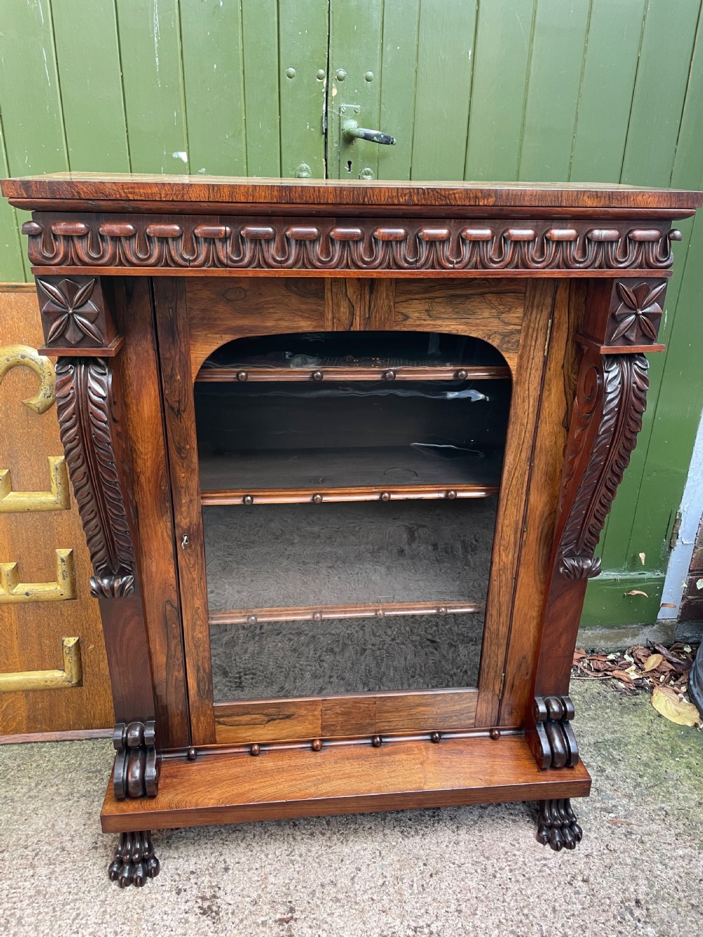 Early C19th George IV period carved rosewood glazed bookcase or pier cabinet of bold design .  View II