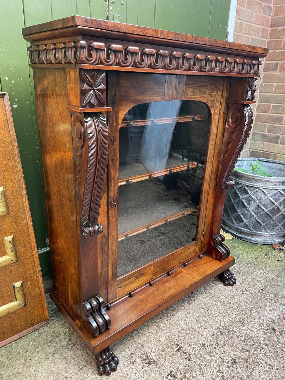Early C19th George IV period carved rosewood glazed bookcase or pier cabinet of bold design .  View III