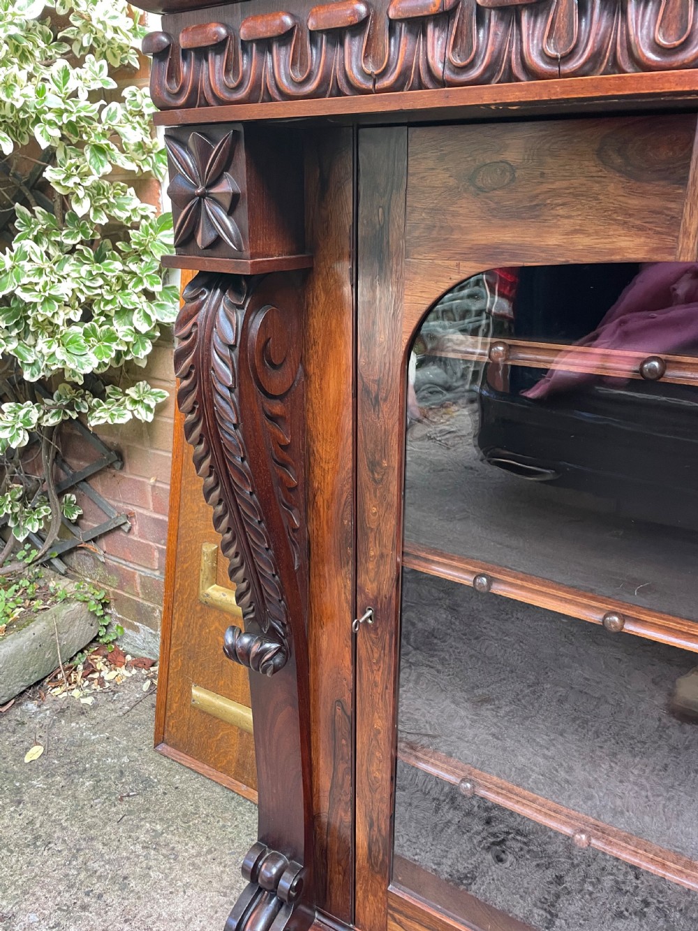 Early C19th George IV period carved rosewood glazed bookcase or pier cabinet of bold design .  View VIII
