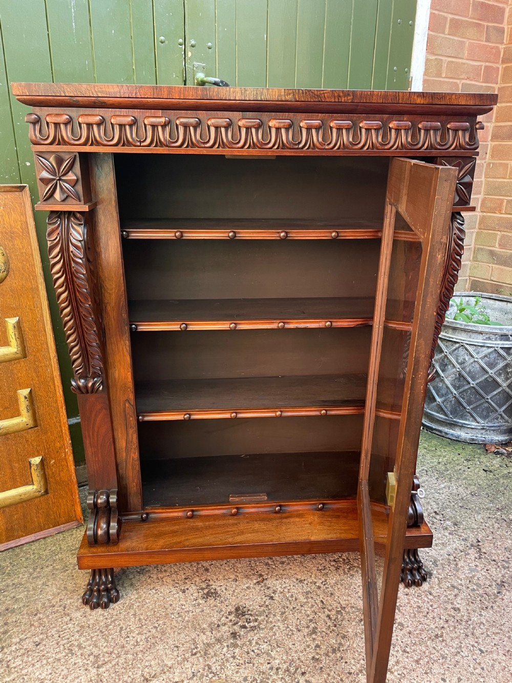 Early C19th George IV period carved rosewood glazed bookcase or pier cabinet of bold design .  View XXV