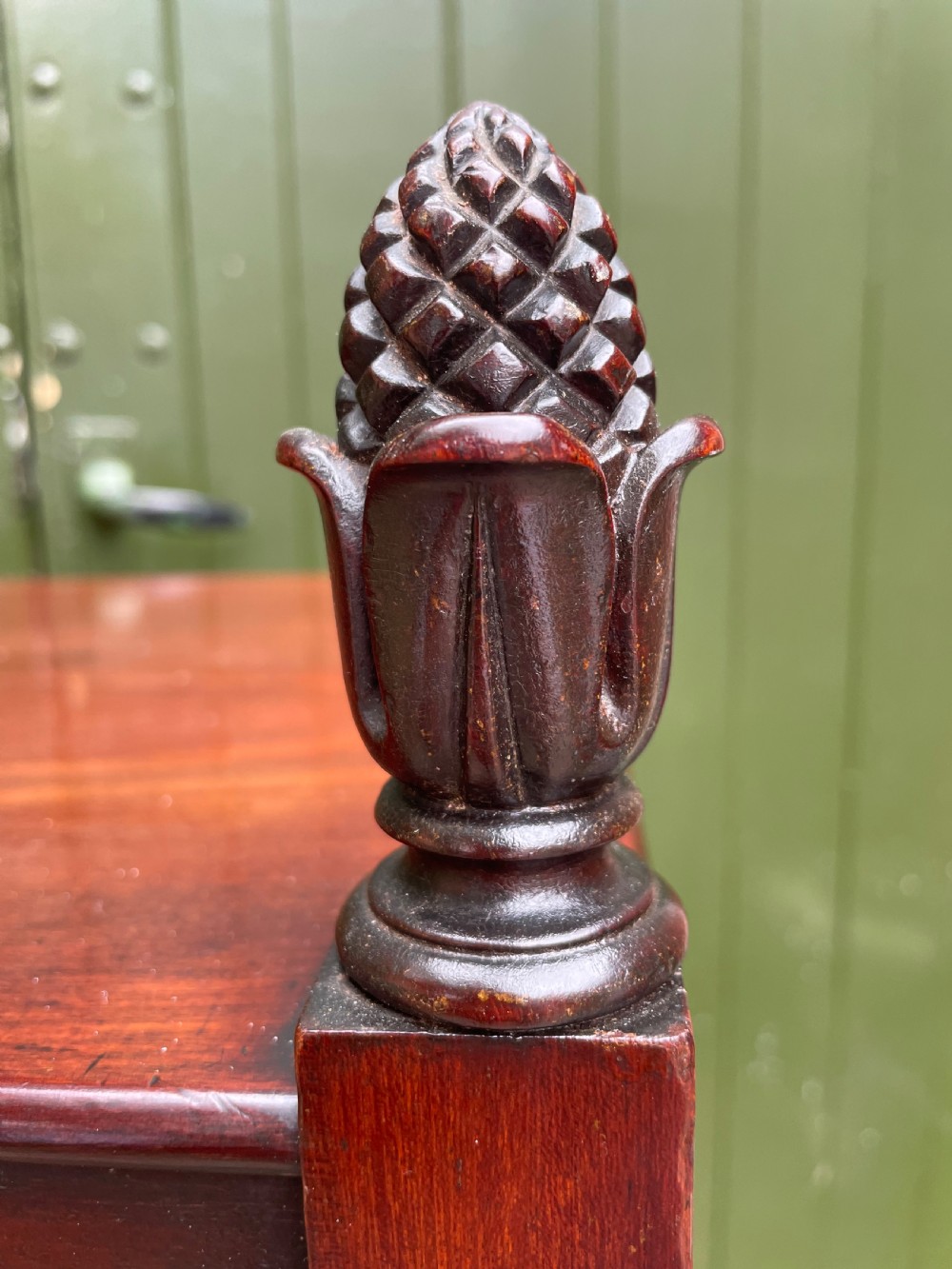 An early nineteenth-century George IV mahogany four-tier etagere featuring carved pinecone finials, turned supports, a single lower drawer, and brass castors. View VI