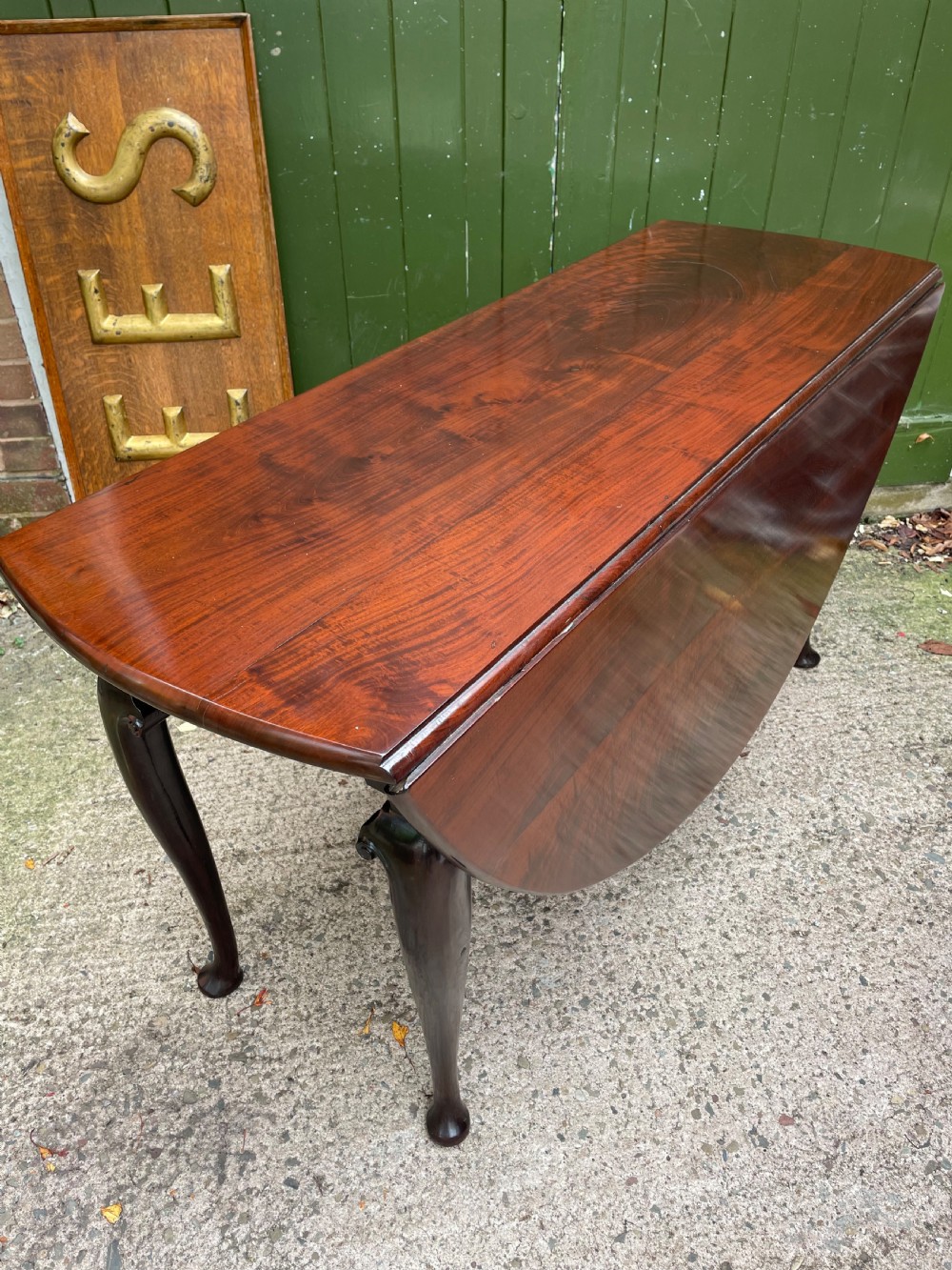 A mid-18th century George II Cuban mahogany drop-leaf table featuring an oval top, cabriole legs, and pad feet. View II