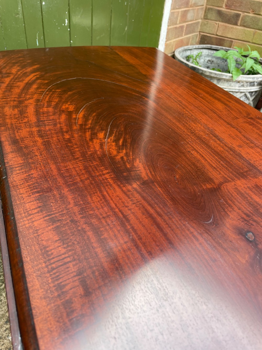 A mid-18th century George II Cuban mahogany drop-leaf table featuring an oval top, cabriole legs, and pad feet. View IV