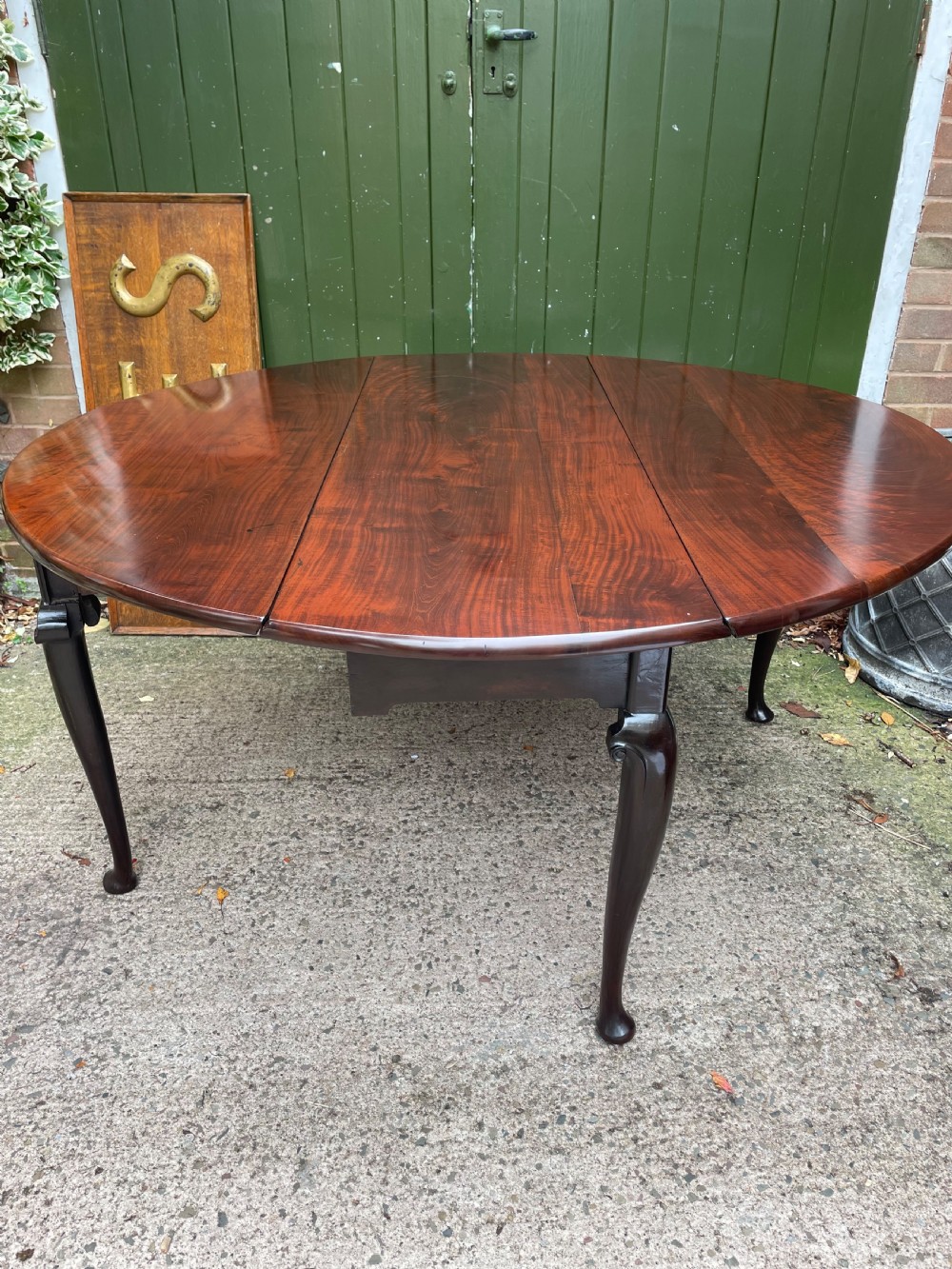 A mid-18th century George II Cuban mahogany drop-leaf table featuring an oval top, cabriole legs, and pad feet. View V