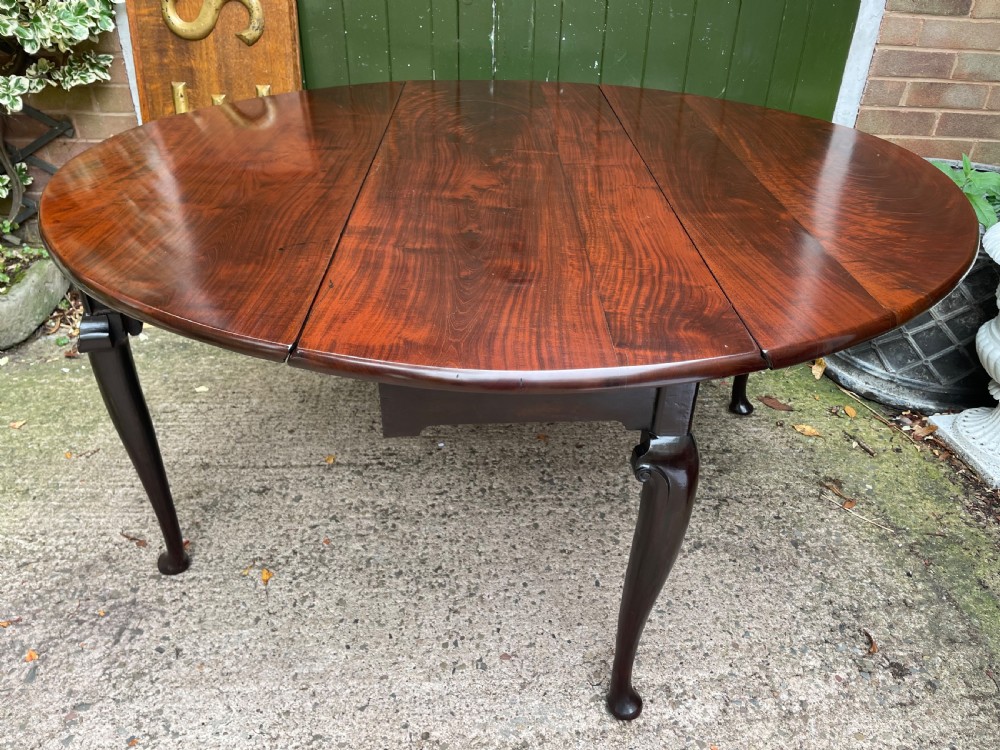 A mid-18th century George II Cuban mahogany drop-leaf table featuring an oval top, cabriole legs, and pad feet. View VII