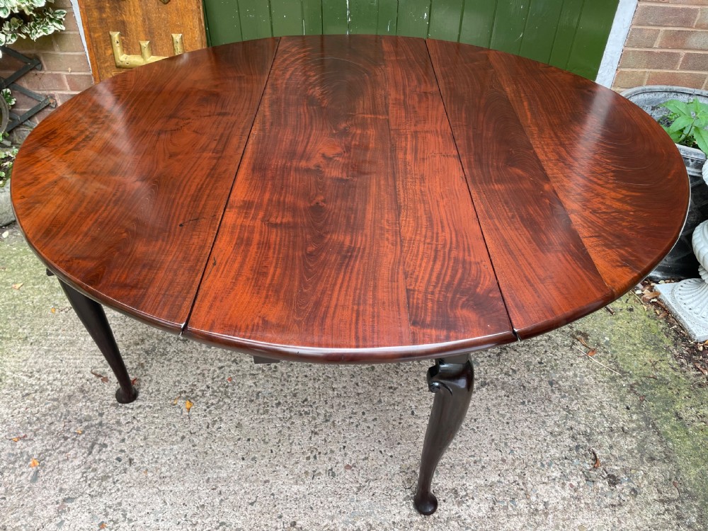 A mid-18th century George II Cuban mahogany drop-leaf table featuring an oval top, cabriole legs, and pad feet. View XI