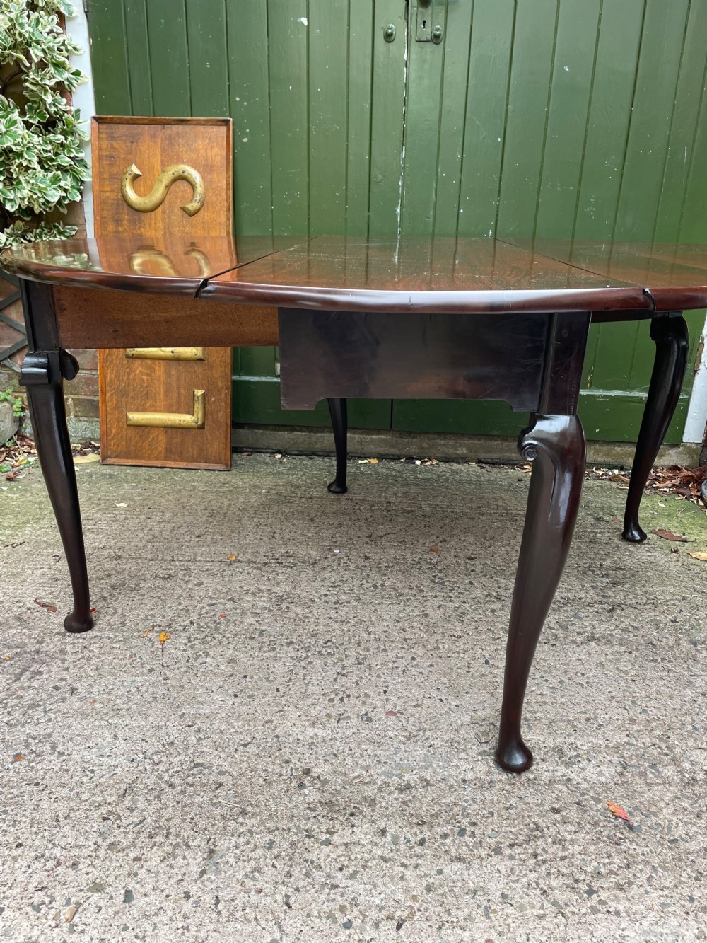 A mid-18th century George II Cuban mahogany drop-leaf table featuring an oval top, cabriole legs, and pad feet. View XII