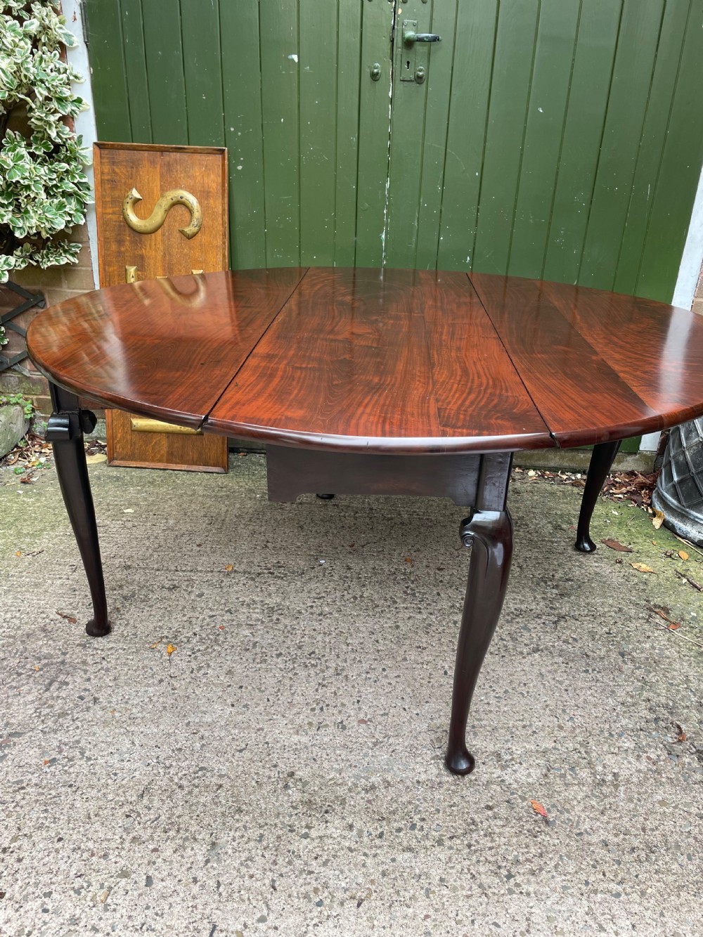 A mid-18th century George II Cuban mahogany drop-leaf table featuring an oval top, cabriole legs, and pad feet. View XIII