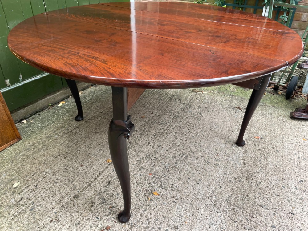 A mid-18th century George II Cuban mahogany drop-leaf table featuring an oval top, cabriole legs, and pad feet. View XV