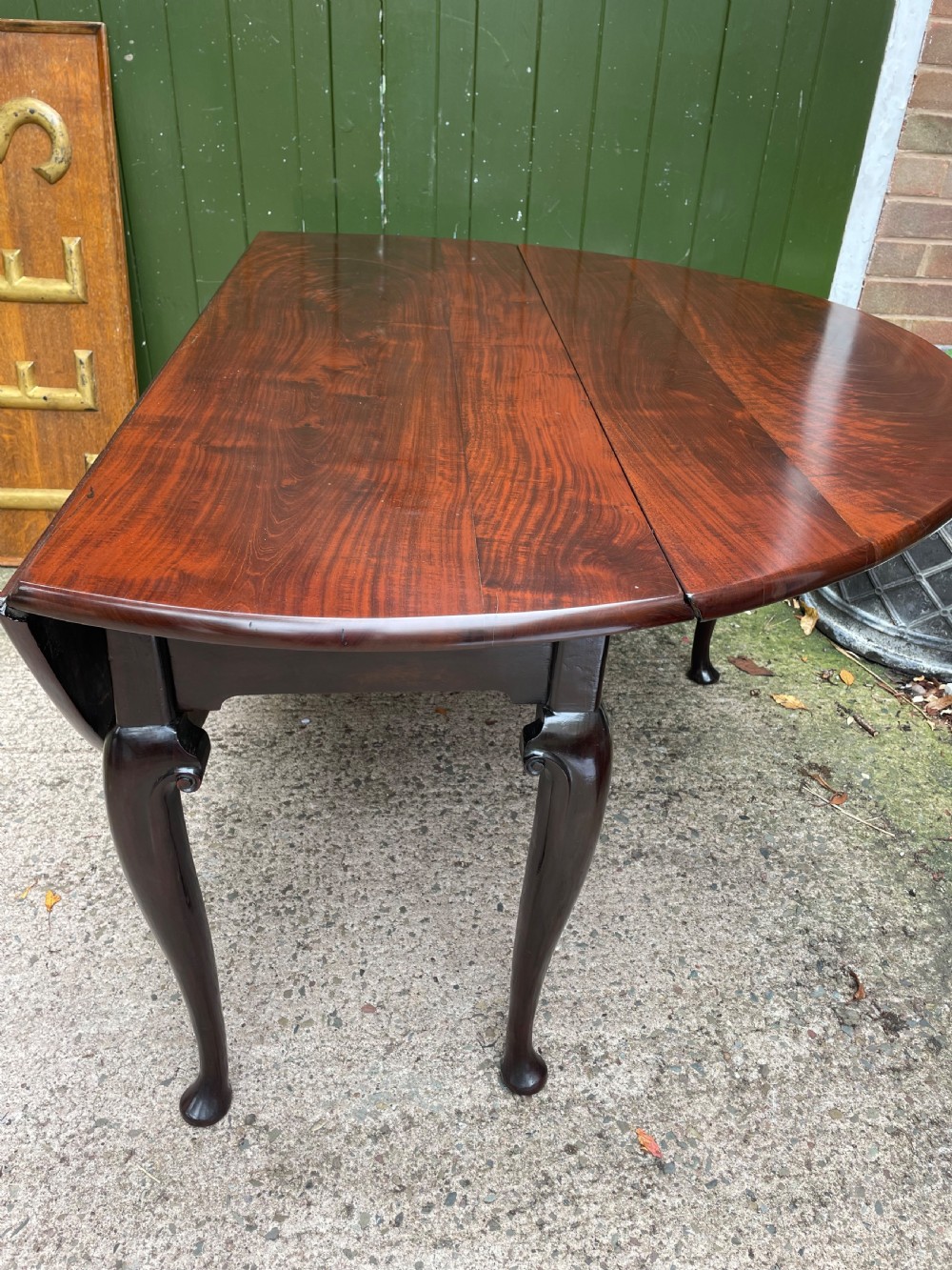 A mid-18th century George II Cuban mahogany drop-leaf table featuring an oval top, cabriole legs, and pad feet. View XVII