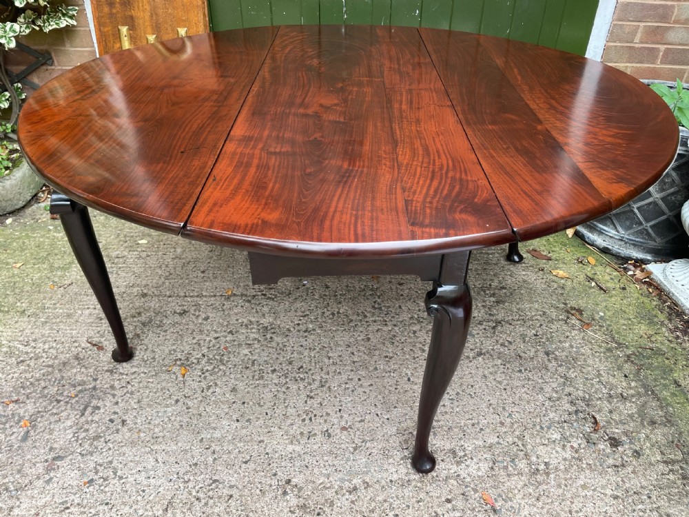 A mid-18th century George II Cuban mahogany drop-leaf table featuring an oval top, cabriole legs, and pad feet. View XVIII
