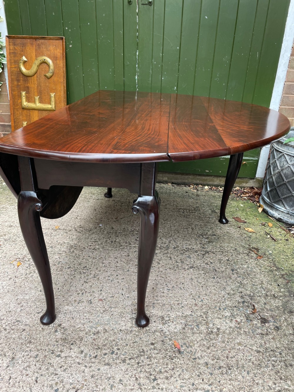 A mid-18th century George II Cuban mahogany drop-leaf table featuring an oval top, cabriole legs, and pad feet. View XIX