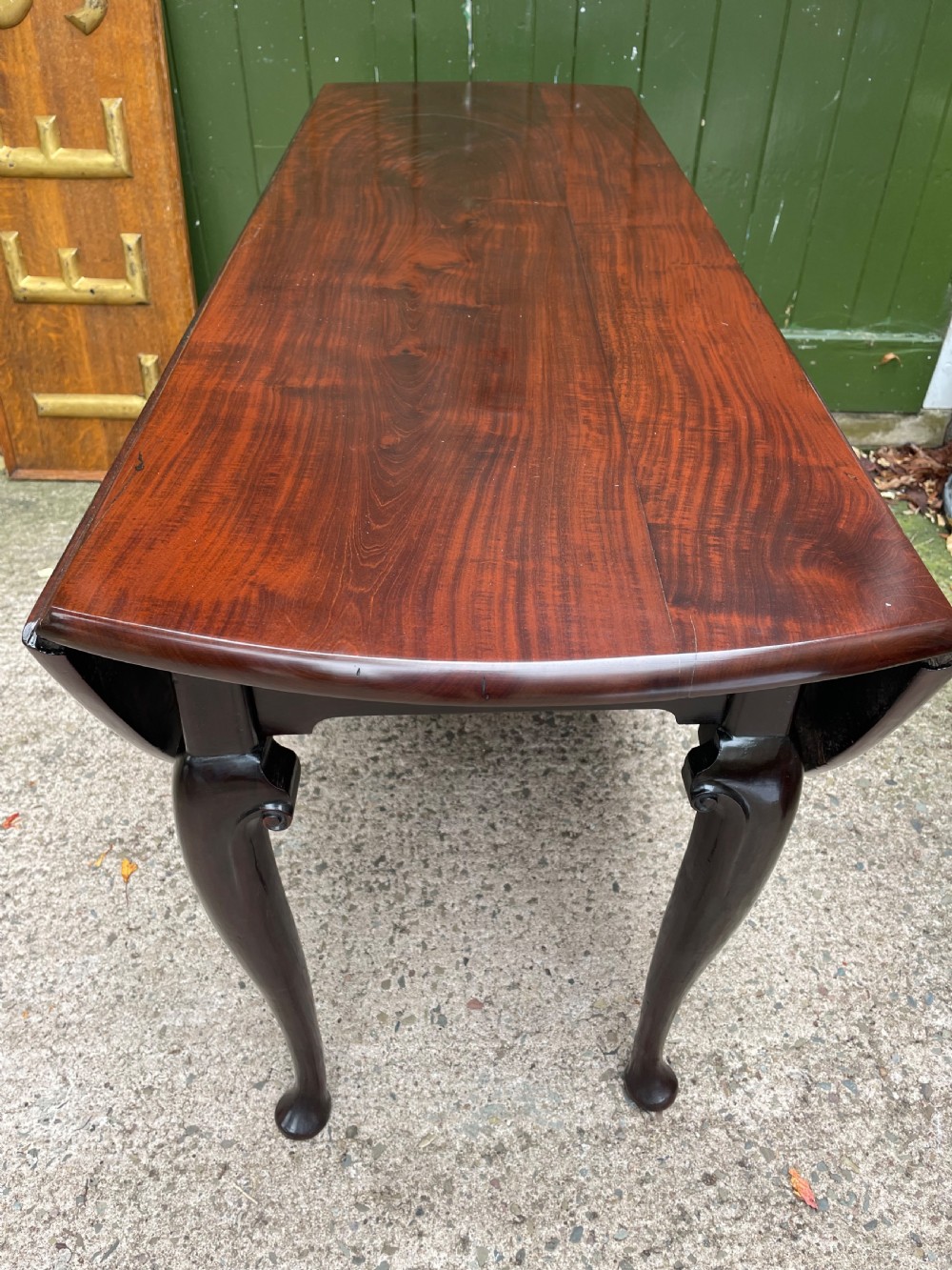 A mid-18th century George II Cuban mahogany drop-leaf table featuring an oval top, cabriole legs, and pad feet. View XX