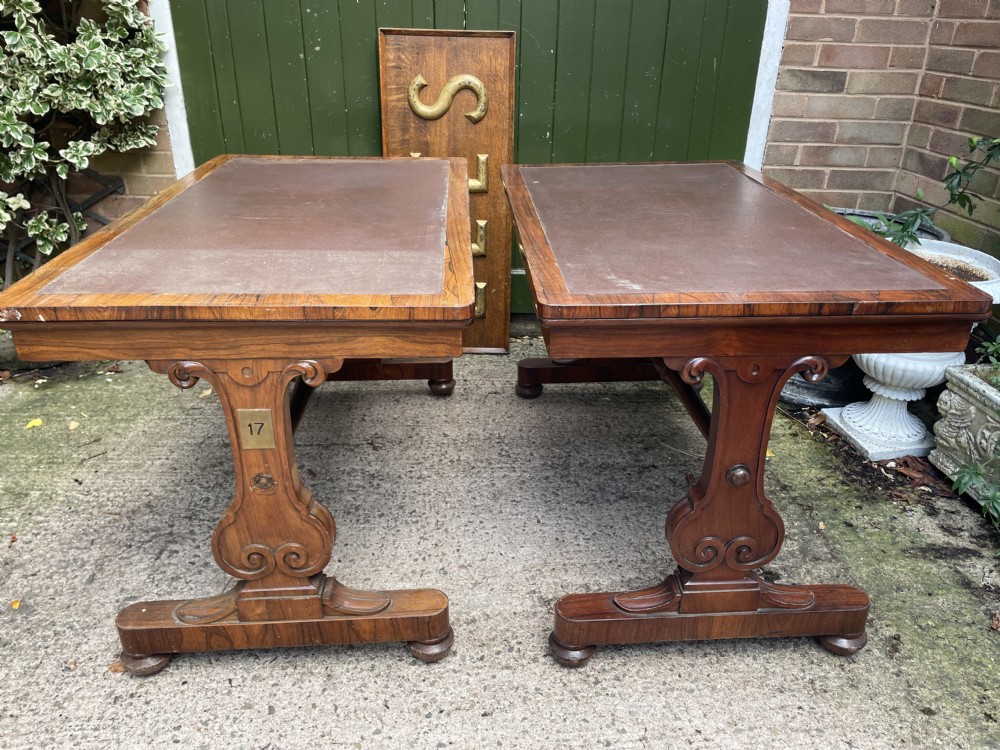 A pair of early nineteenth-century George IV rosewood library tables featuring brown leather writing surfaces, carved scroll end supports, and turned stretchers. View XVII
