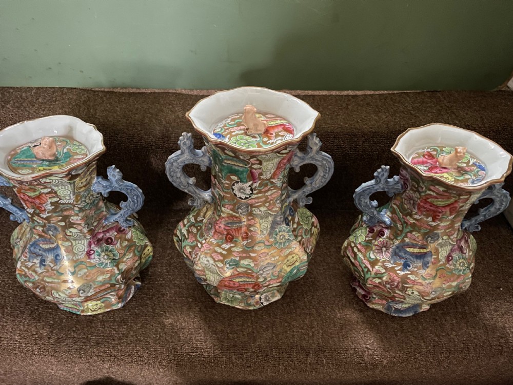 A three-piece nineteenth-century Masons Ironstone garniture set decorated with Chinoiserie enamel patterns, blue handles, and lion lid finials. View VI