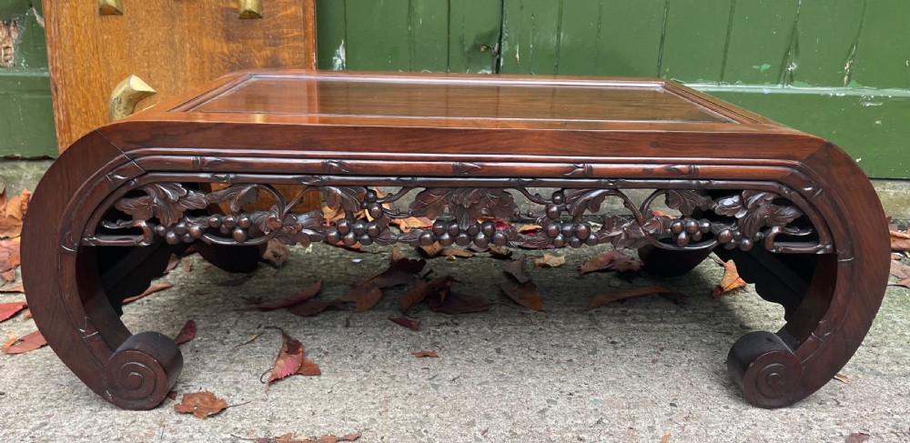 A low Chinese huali wood kang table featuring an openwork carved apron and scroll-end legs. View II