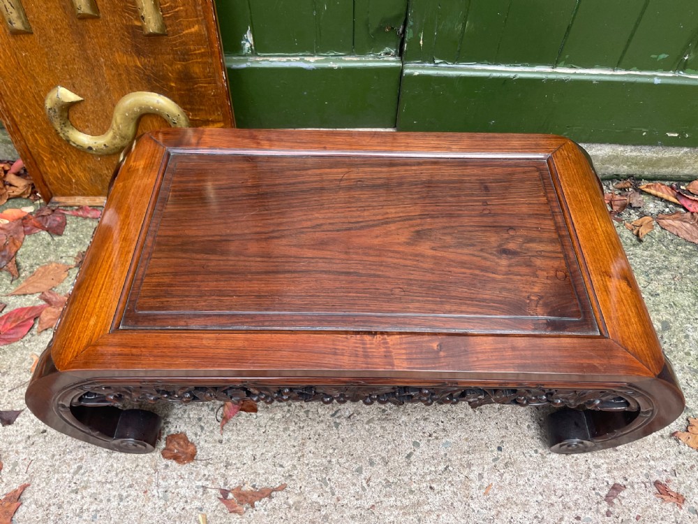 A low Chinese huali wood kang table featuring an openwork carved apron and scroll-end legs. View III