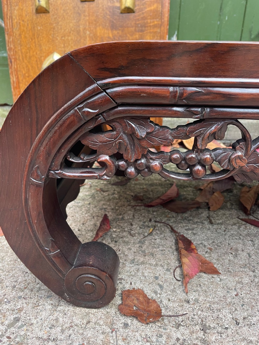 A low Chinese huali wood kang table featuring an openwork carved apron and scroll-end legs. View IV