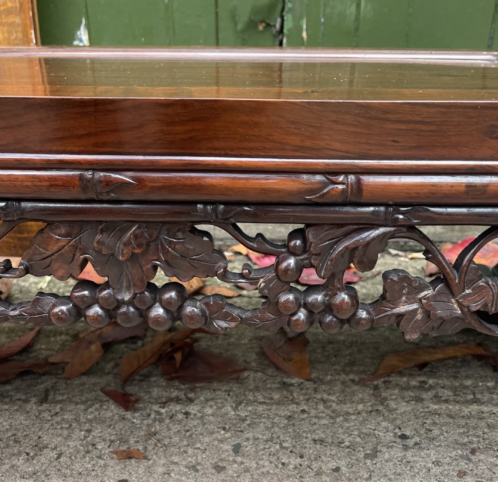 A low Chinese huali wood kang table featuring an openwork carved apron and scroll-end legs. View V