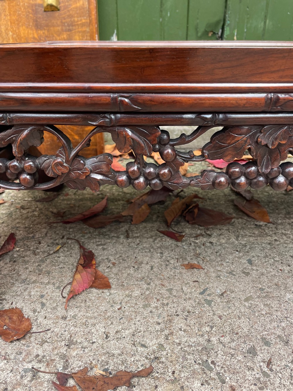 A low Chinese huali wood kang table featuring an openwork carved apron and scroll-end legs. View VI
