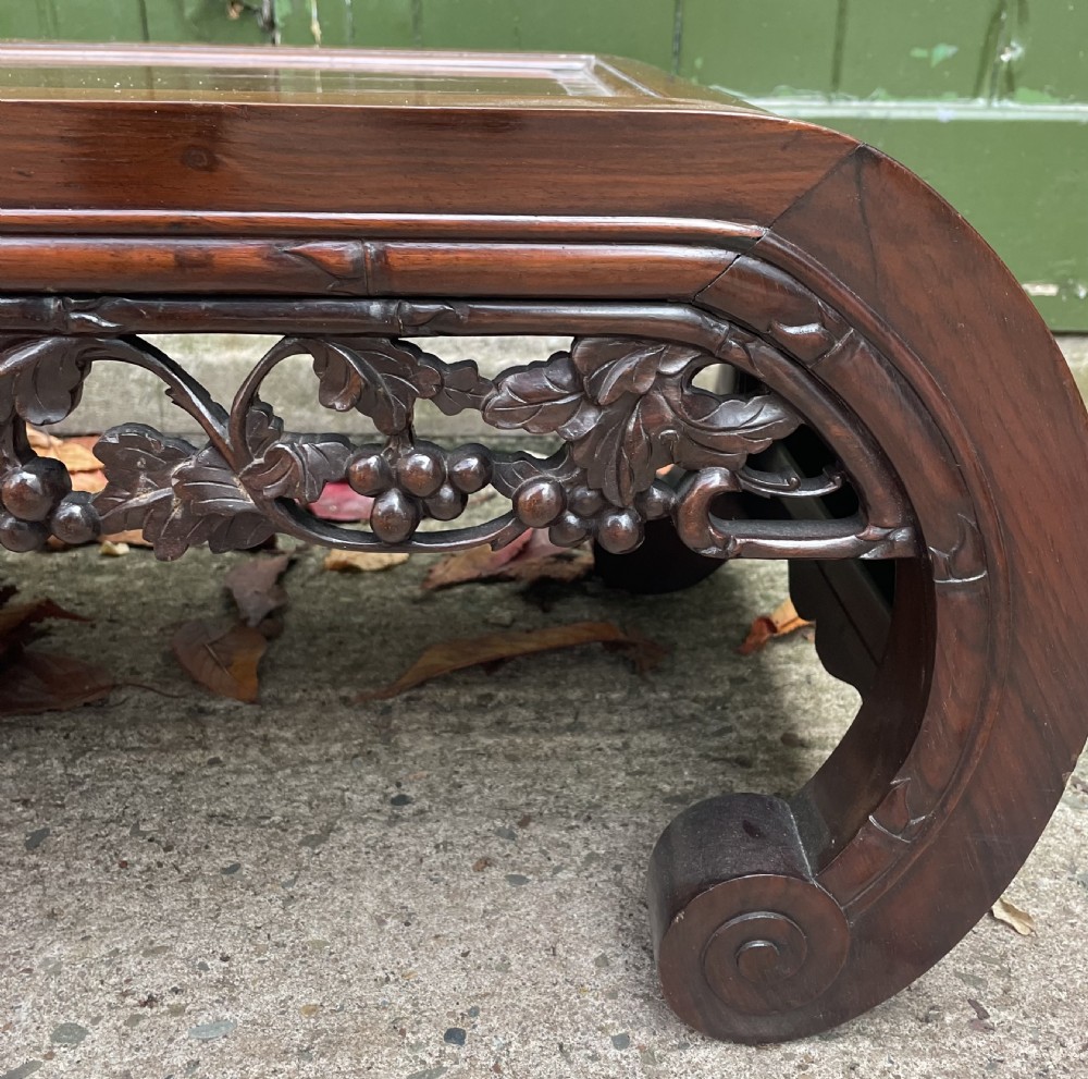 A low Chinese huali wood kang table featuring an openwork carved apron and scroll-end legs. View VII