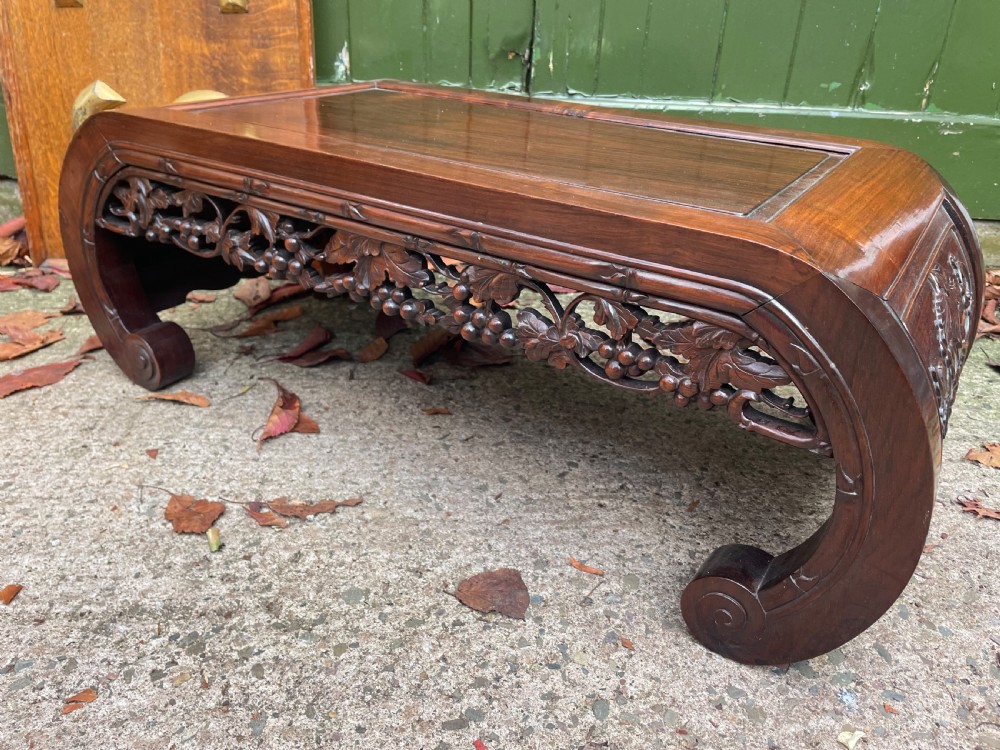 A low Chinese huali wood kang table featuring an openwork carved apron and scroll-end legs. View X