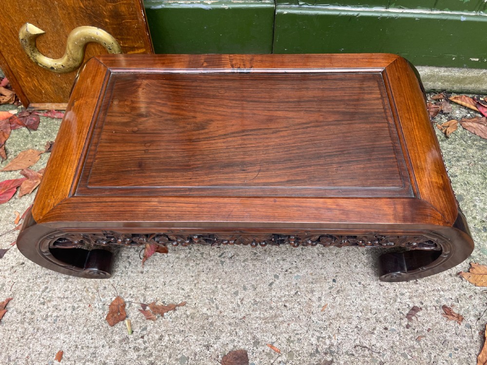 A low Chinese huali wood kang table featuring an openwork carved apron and scroll-end legs. View XII