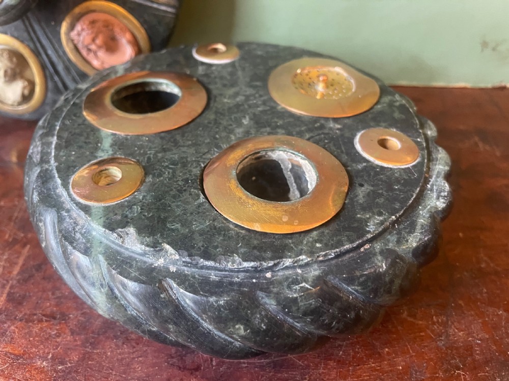 A circular dark green carved Prato Verde marble inkstand with fluted sides, set with six oval carved Vesuvian lava portrait cameos framed in brass mounts around a central raised finial. View VI