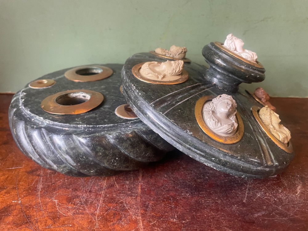 A circular dark green carved Prato Verde marble inkstand with fluted sides, set with six oval carved Vesuvian lava portrait cameos framed in brass mounts around a central raised finial. View XIV
