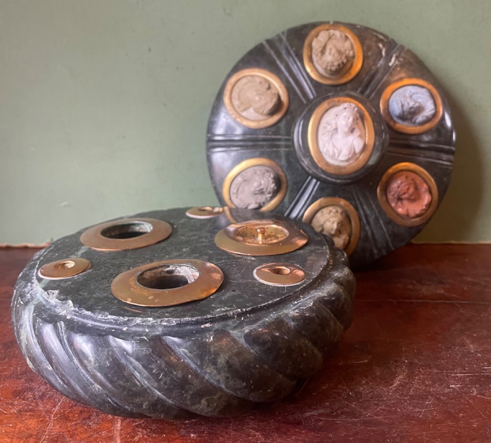 A circular dark green carved Prato Verde marble inkstand with fluted sides, set with six oval carved Vesuvian lava portrait cameos framed in brass mounts around a central raised finial. View XV