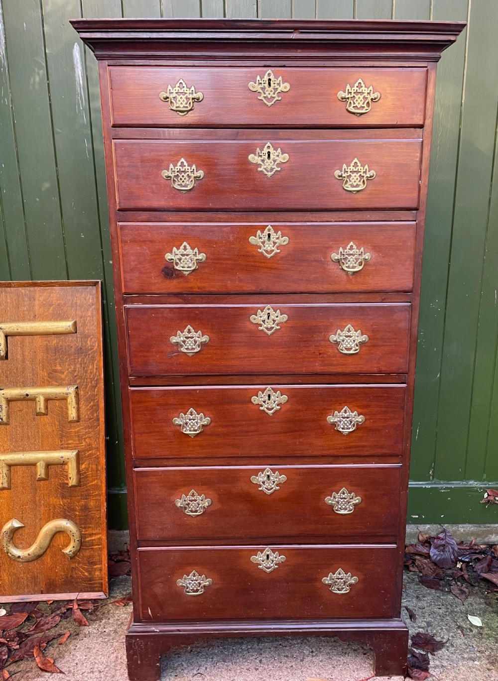 A mid-18th-century George III mahogany tallboy chest comprising seven graduated drawers with decorative pierced brass handles and bracket feet. View VI