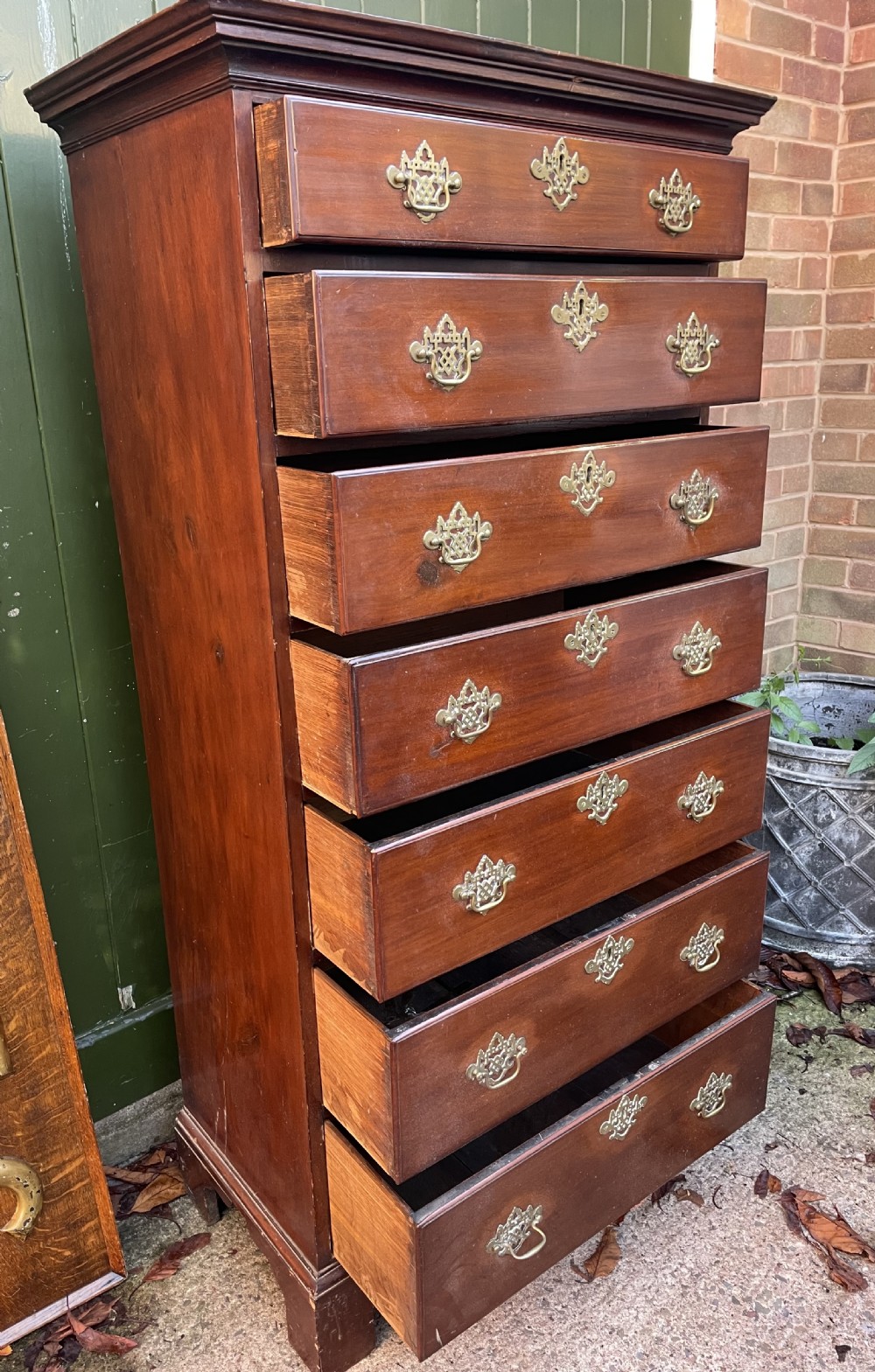 A mid-18th-century George III mahogany tallboy chest comprising seven graduated drawers with decorative pierced brass handles and bracket feet. View XI
