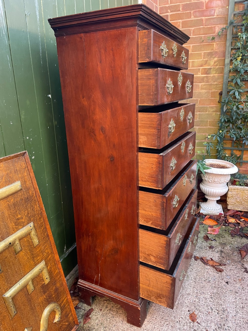 A mid-18th-century George III mahogany tallboy chest comprising seven graduated drawers with decorative pierced brass handles and bracket feet. View XII