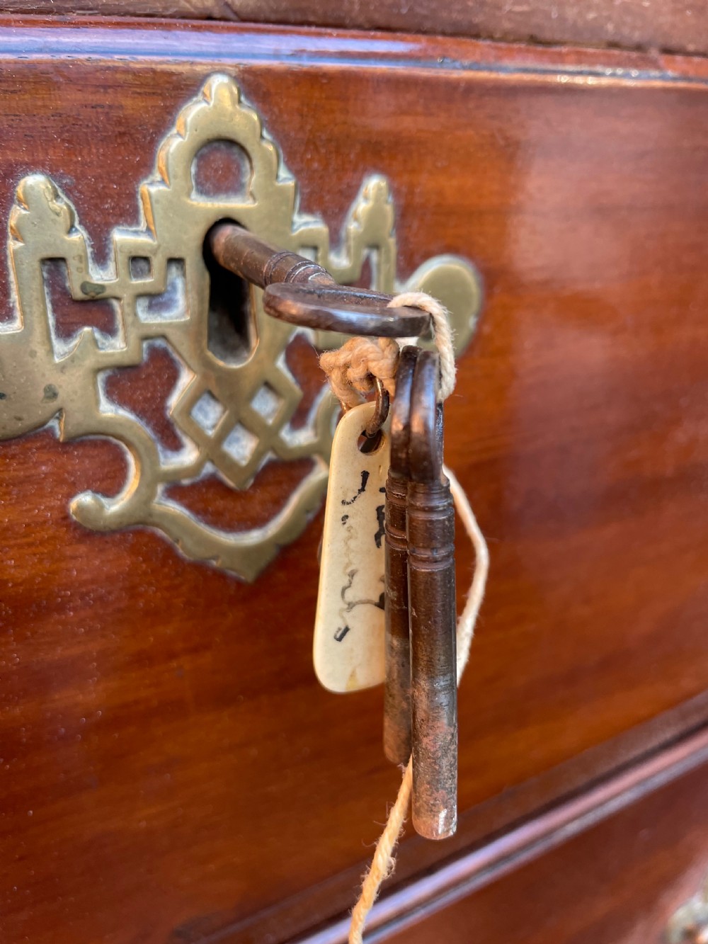 A mid-18th-century George III mahogany tallboy chest comprising seven graduated drawers with decorative pierced brass handles and bracket feet. View XIV