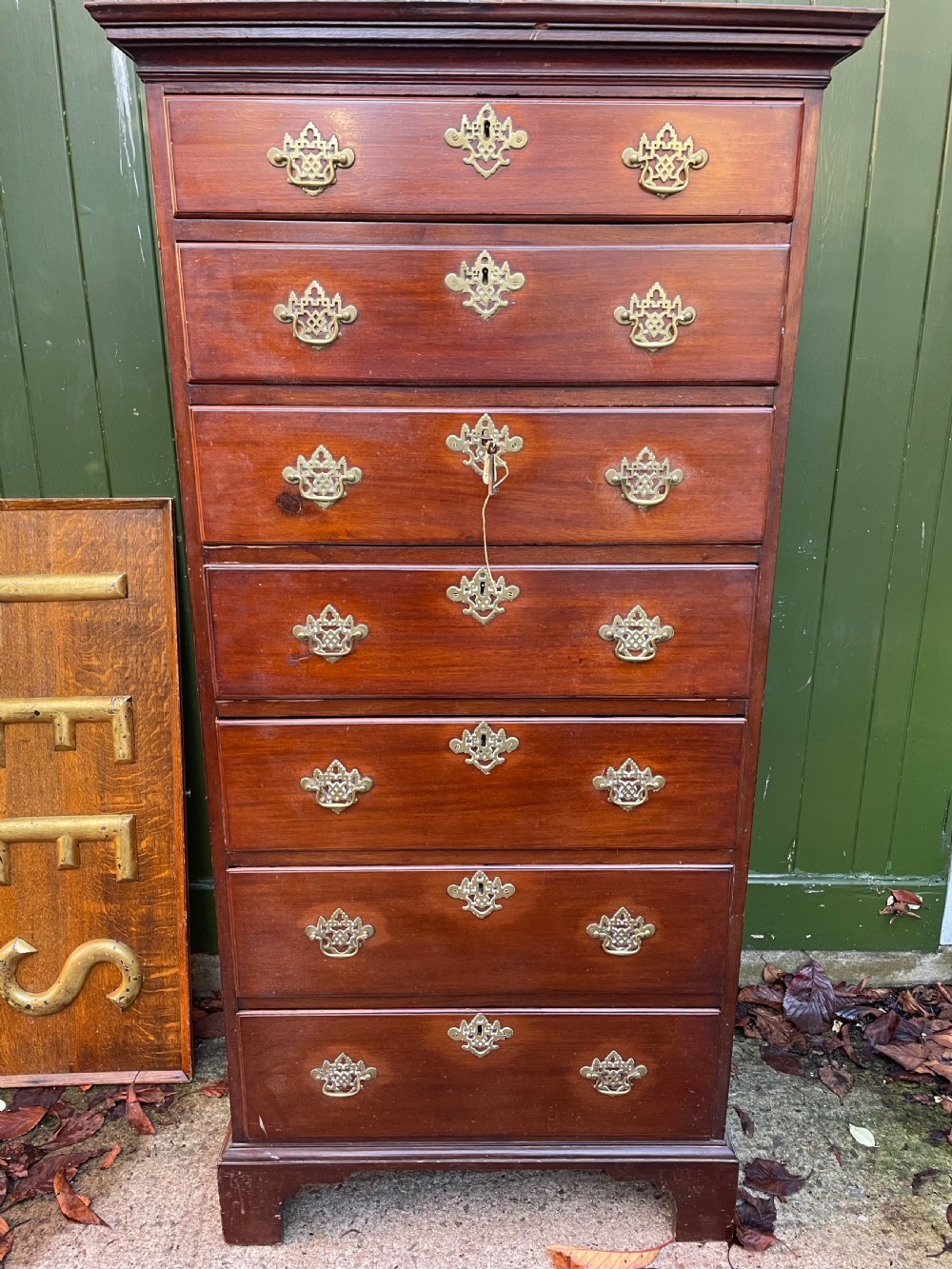 A mid-18th-century George III mahogany tallboy chest comprising seven graduated drawers with decorative pierced brass handles and bracket feet. View XV