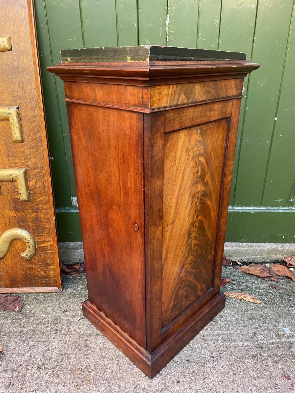 An early nineteenth-century Georgian mahogany pedestal cupboard featuring a flame mahogany veneered front panel, moulded top cornice, and plinth base. View III