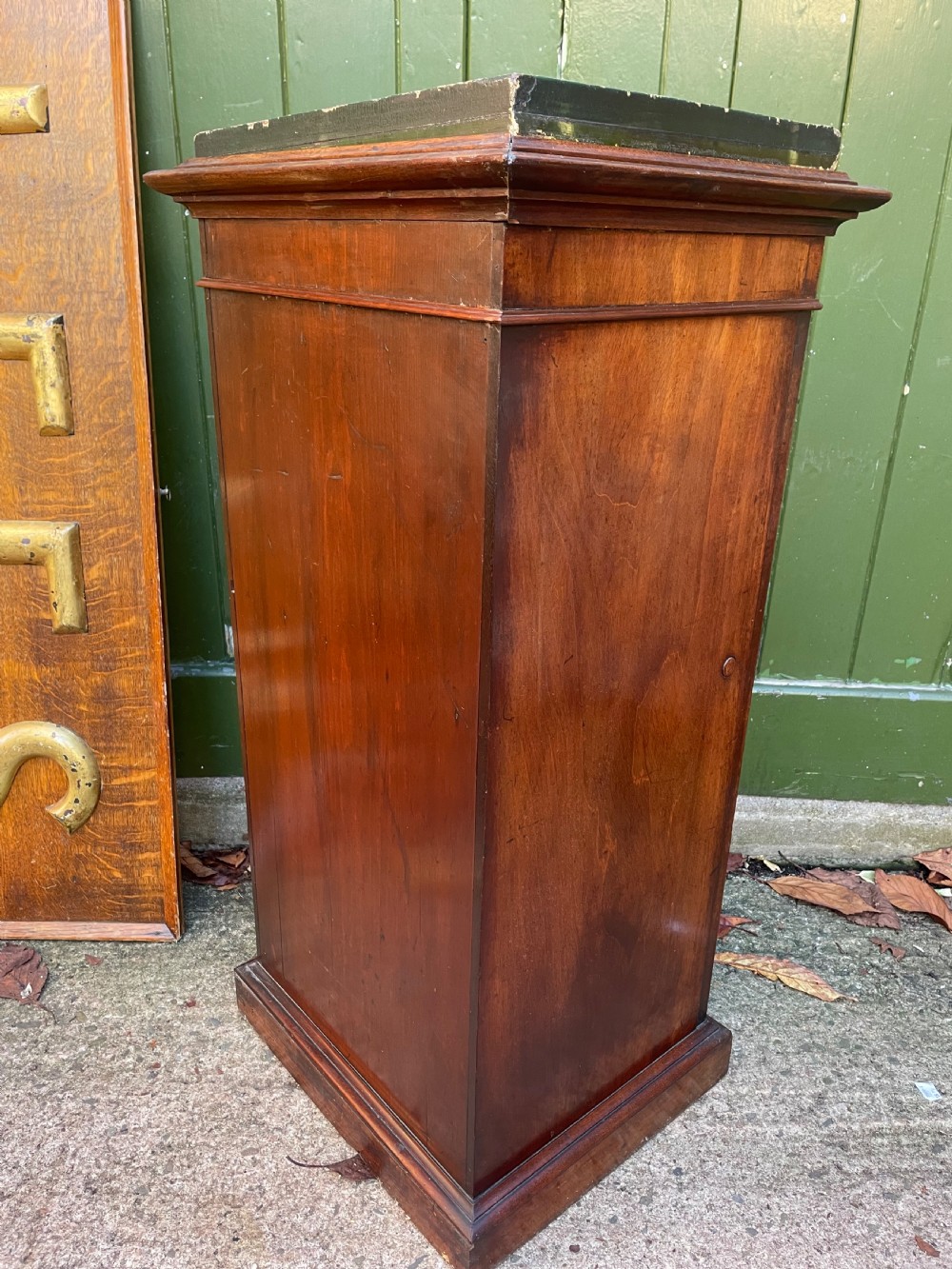 An early nineteenth-century Georgian mahogany pedestal cupboard featuring a flame mahogany veneered front panel, moulded top cornice, and plinth base. View V