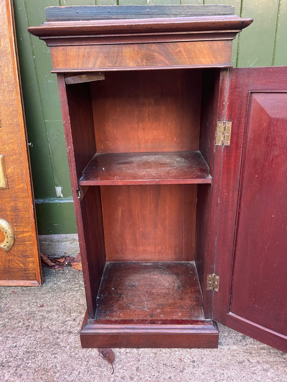 An early nineteenth-century Georgian mahogany pedestal cupboard featuring a flame mahogany veneered front panel, moulded top cornice, and plinth base. View VI