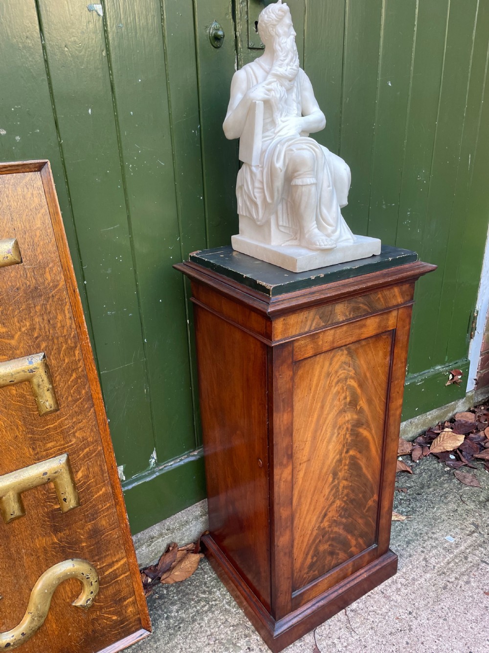 An early nineteenth-century Georgian mahogany pedestal cupboard featuring a flame mahogany veneered front panel, moulded top cornice, and plinth base. View XIII