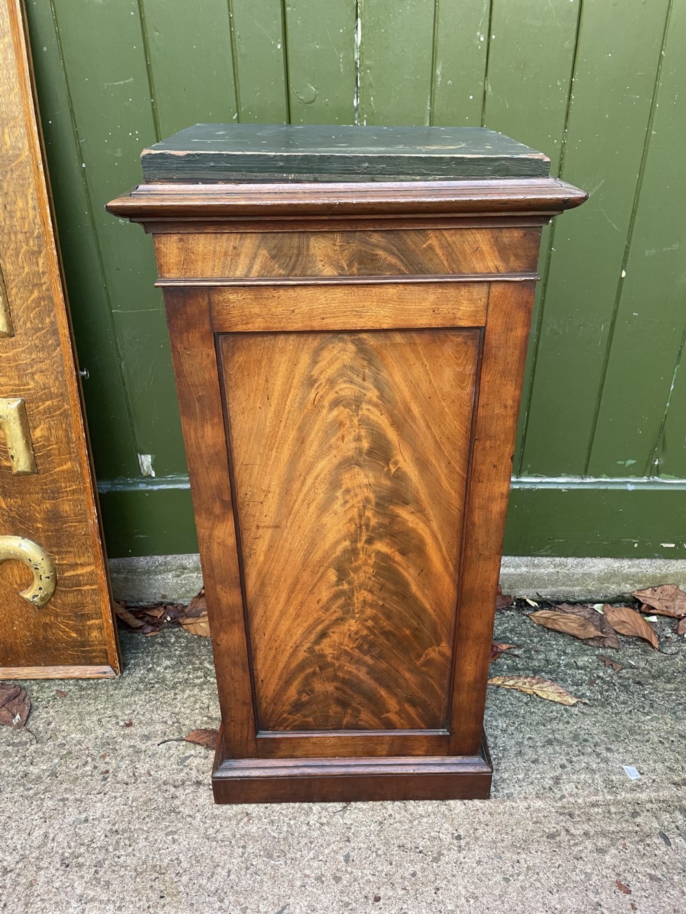 An early nineteenth-century Georgian mahogany pedestal cupboard featuring a flame mahogany veneered front panel, moulded top cornice, and plinth base. View XV