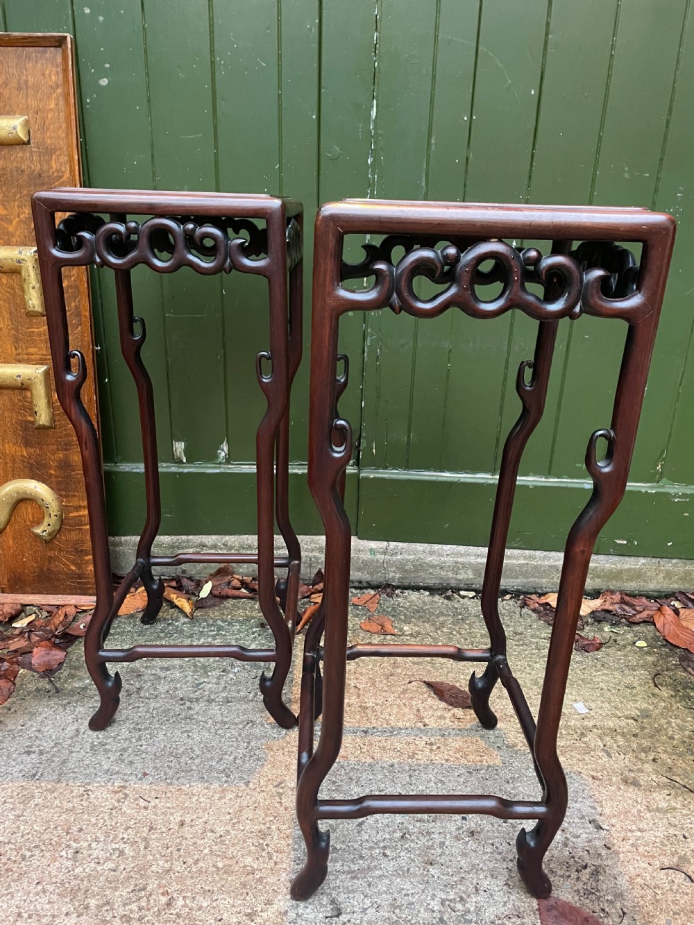 A pair of tall late 19th-century Chinese Qing Dynasty dark hardwood stands featuring square tops, openwork carved scroll aprons, and slender serpentine legs. View VII