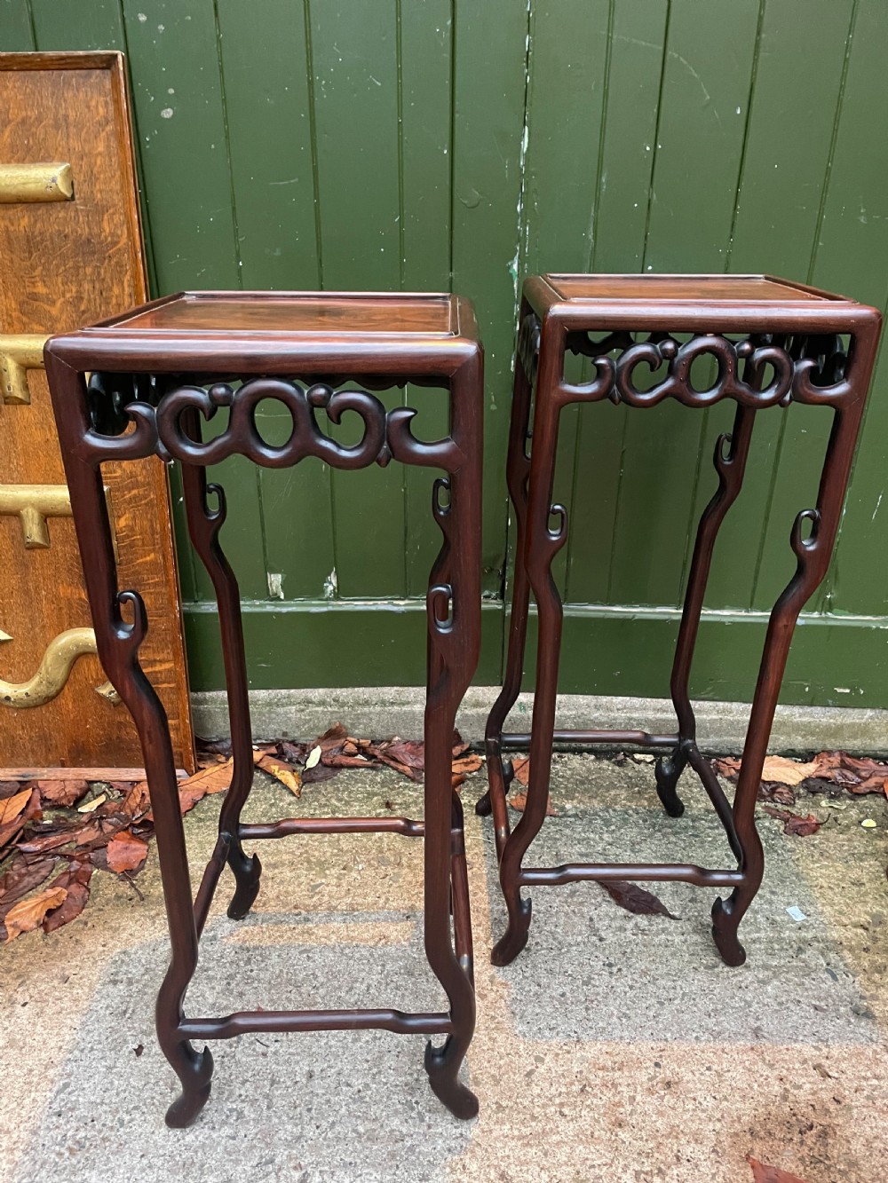 A pair of tall late 19th-century Chinese Qing Dynasty dark hardwood stands featuring square tops, openwork carved scroll aprons, and slender serpentine legs. View IX