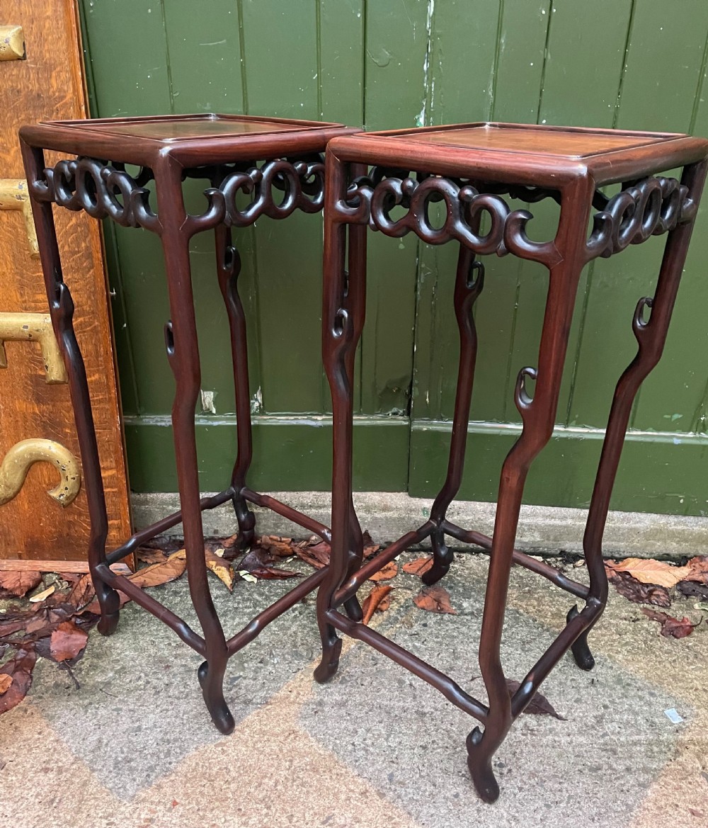 A pair of tall late 19th-century Chinese Qing Dynasty dark hardwood stands featuring square tops, openwork carved scroll aprons, and slender serpentine legs. View XV